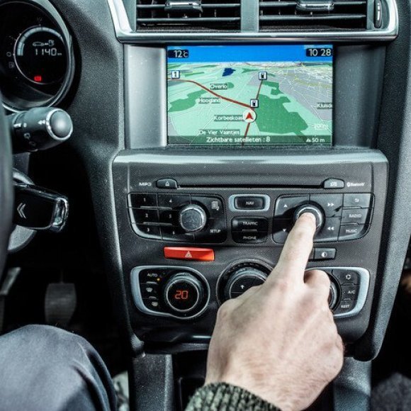 Hand die navigatie in de auto instelt voor vertrek.