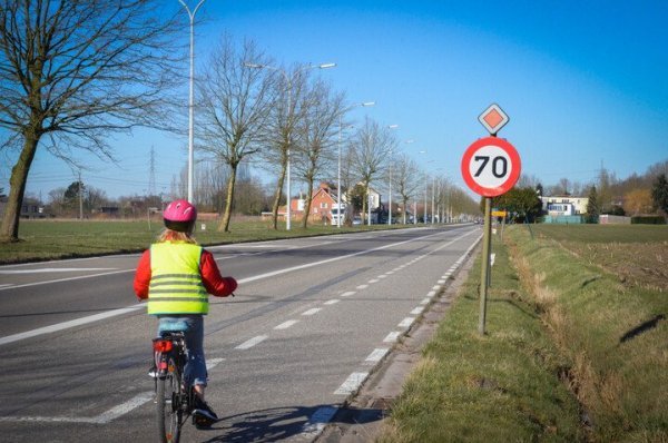 kind fietst langs gewestwegmet  70 km/u snelheidslimiet