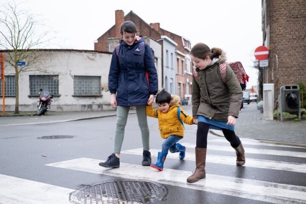 3 kinderen die hand in hand oversteken op een zebrapad