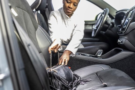 vrouw die gsm wegstopt in handtas in de auto