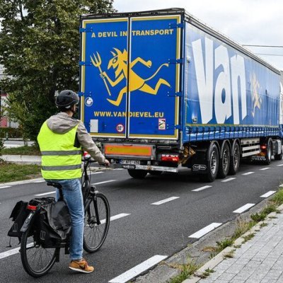 fietser die 3 meter achter een vrachtwagen wacht op het fietspad aan een kruispunt