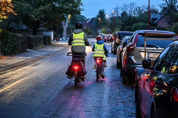 Moeder en kinderen fietsend in het donker met goede fietsverlichting