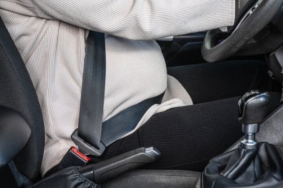 zwangere vrouw die autogordel draagt