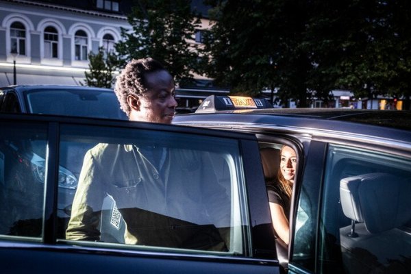 in een taxi stappende man