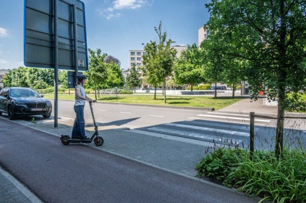vrouw op e-step aan zebrapad