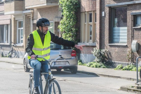 fietser die arm uitsteekt om links af te slaan