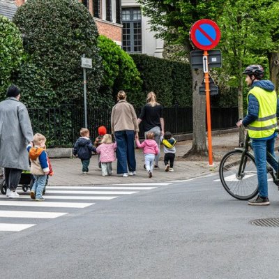 Fietser die stopt op kruispunt voor overstekende kinderen op zebrapad